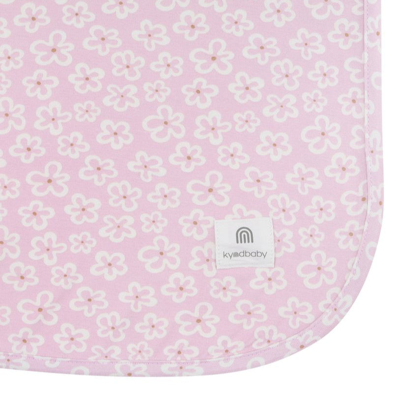 Floral patterned fabric with a visible brand logo on a pink background