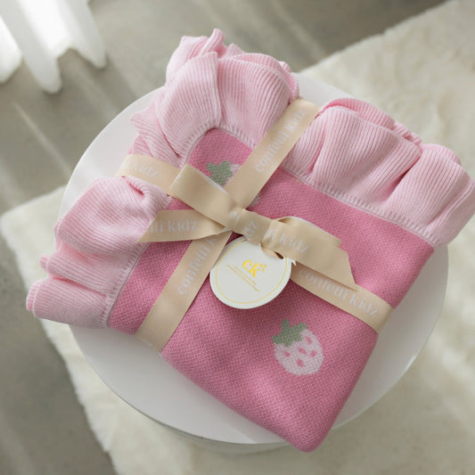 Pink baby outfit with a bow on a white surface