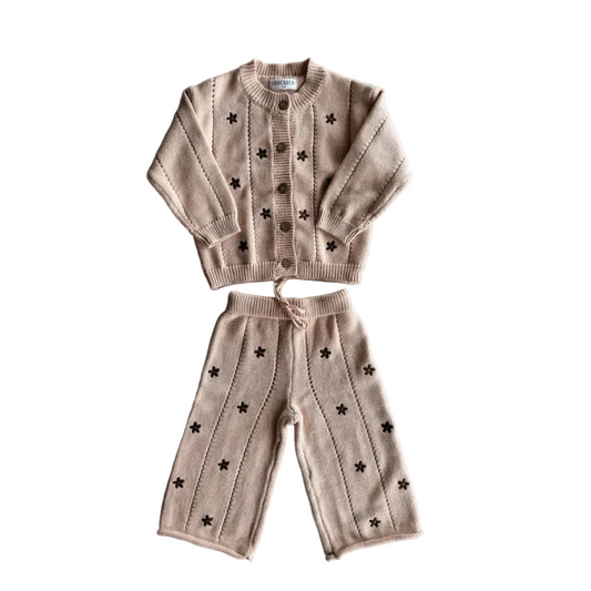 Knitted children's set with sweater and pants on a gray background
