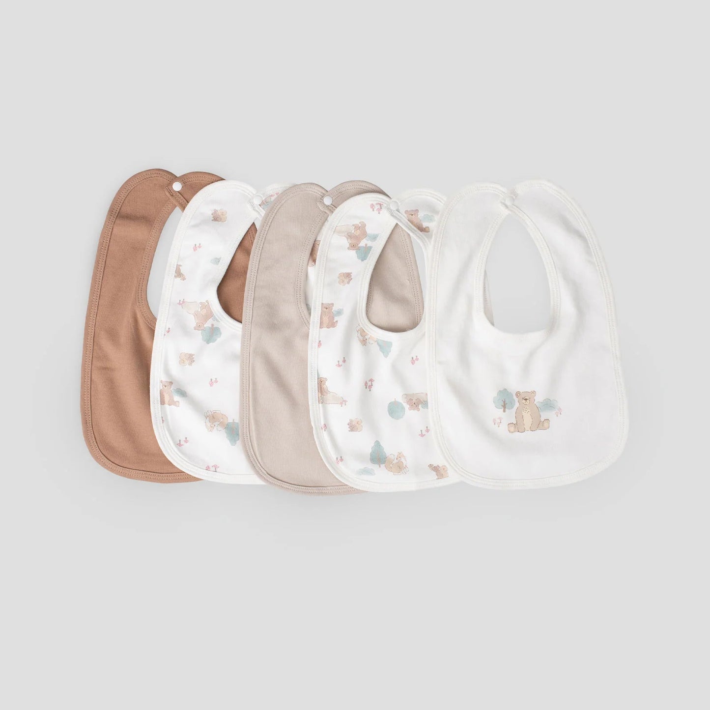 Set of five baby bibs in various colors on a light gray background