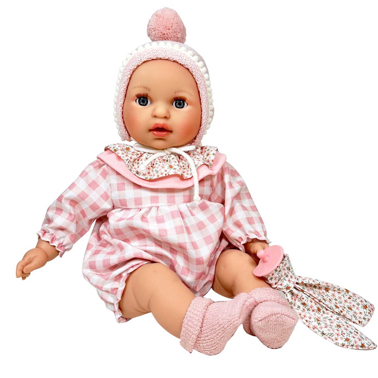 Baby doll in pink checkered outfit with matching hat on a white background