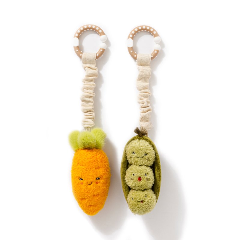 Two plush toys shaped like a carrot and a pod with faces on a white background