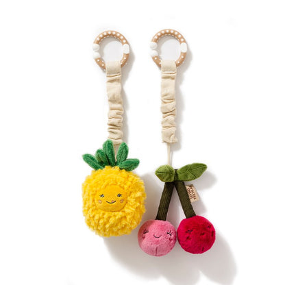 Two plush toys shaped like a pineapple and cherries on a white background