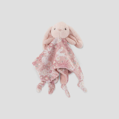 Pink plush bunny with a floral blanket on a light gray background