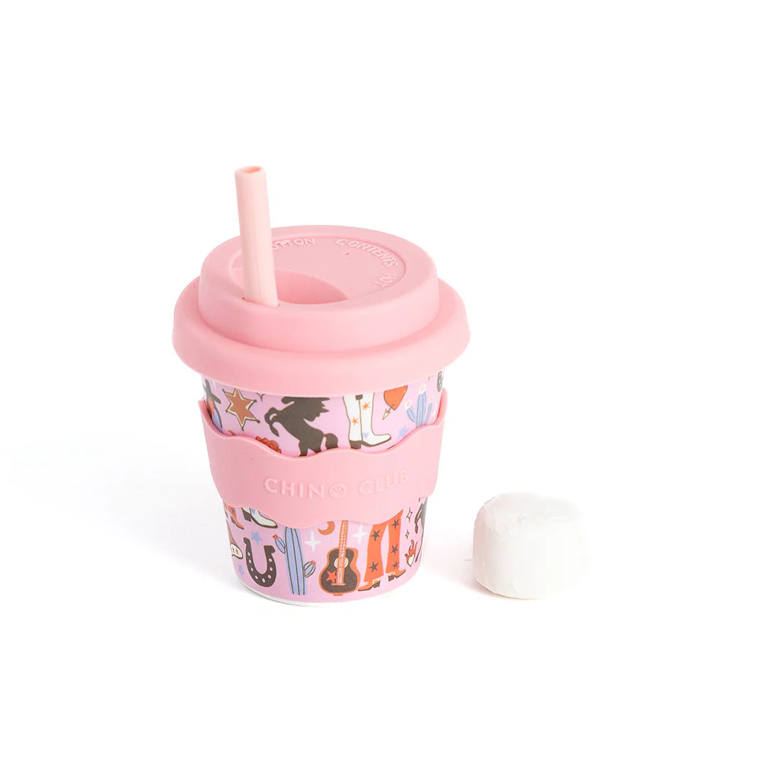 Pink tumbler with a patterned sleeve and straw on a white background