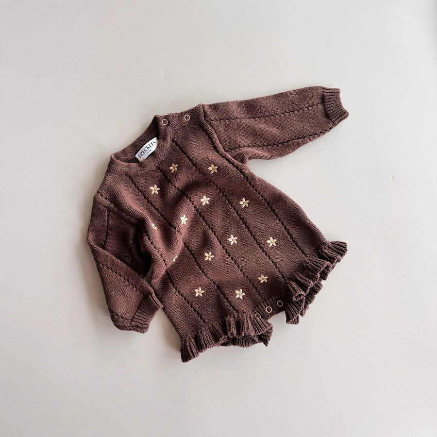 Brown baby outfit with star pattern on a light gray background