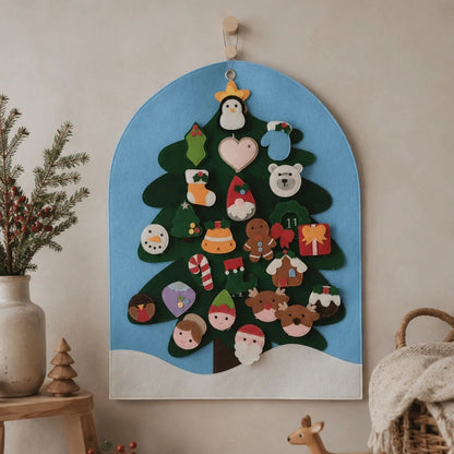 A wooden Christmas advent tree wall hanging with colorful felt ornaments, displayed on a beige wall in a styled room setting with a wooden toy deer, basket, and dried flowers.