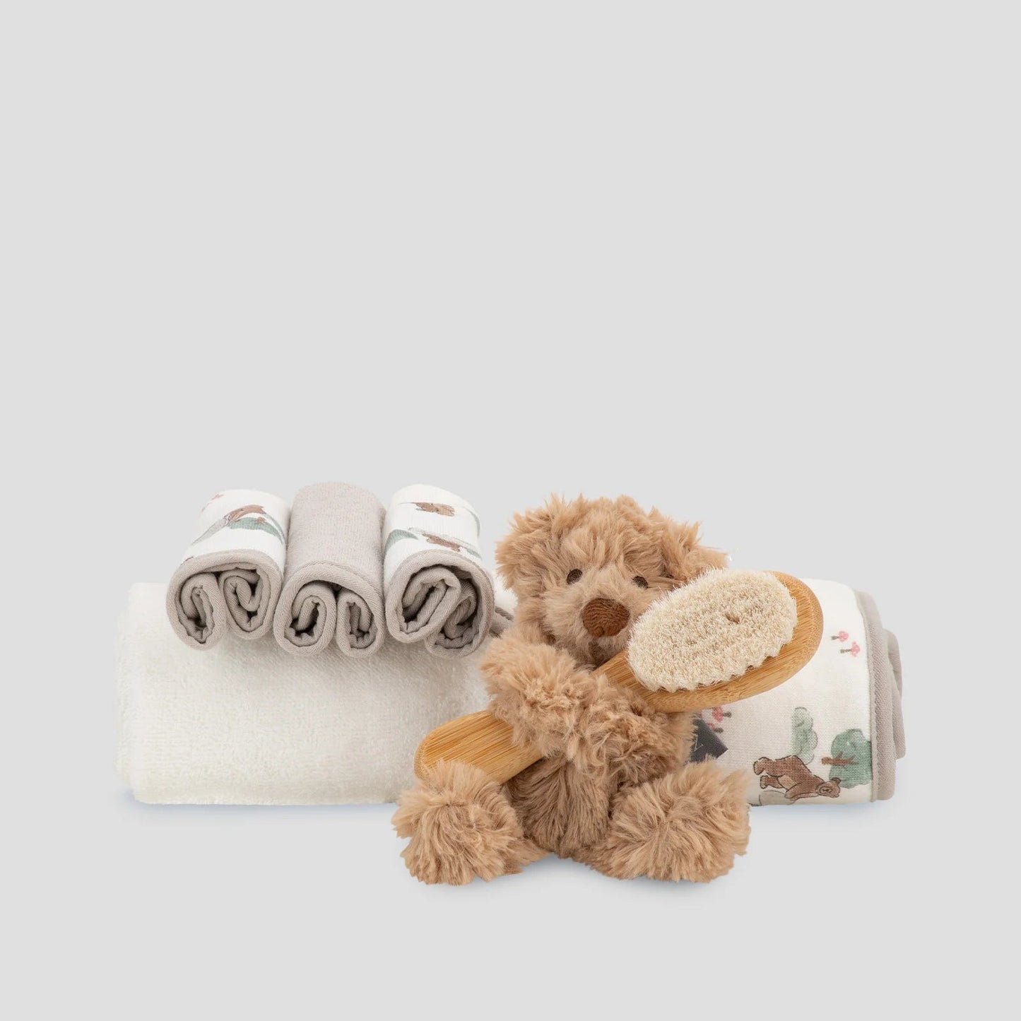 Baby blanket with teddy bear design and plush toy on a light gray background