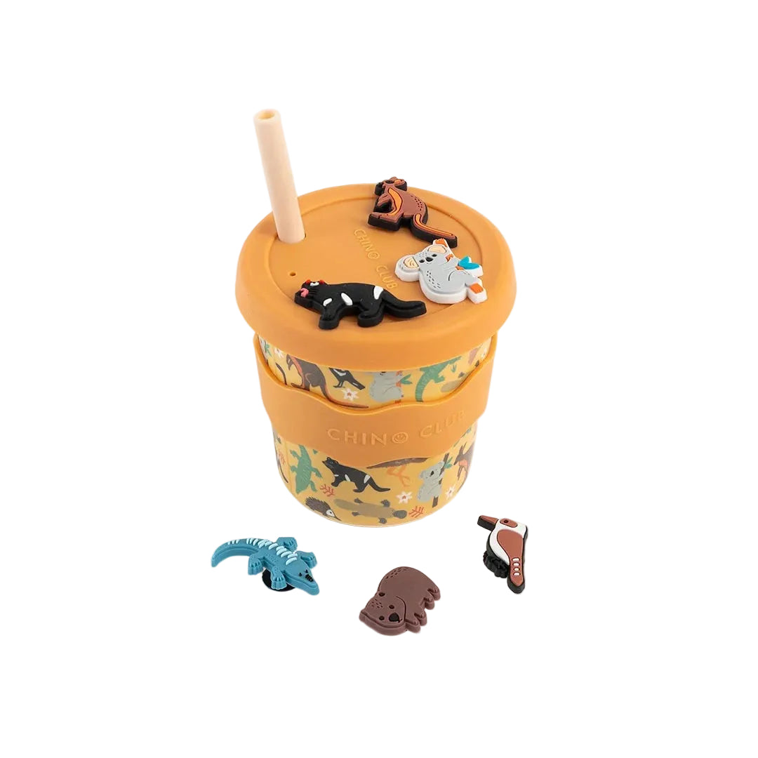 Orange cup with animal-themed silicone charms on a white background