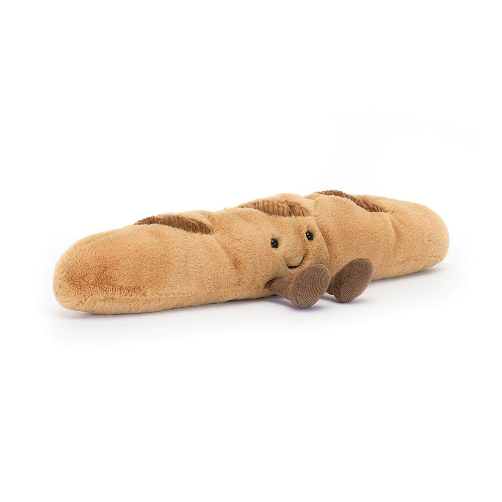 JELLYCAT Plush toy shaped like a baguette with a face on a white background