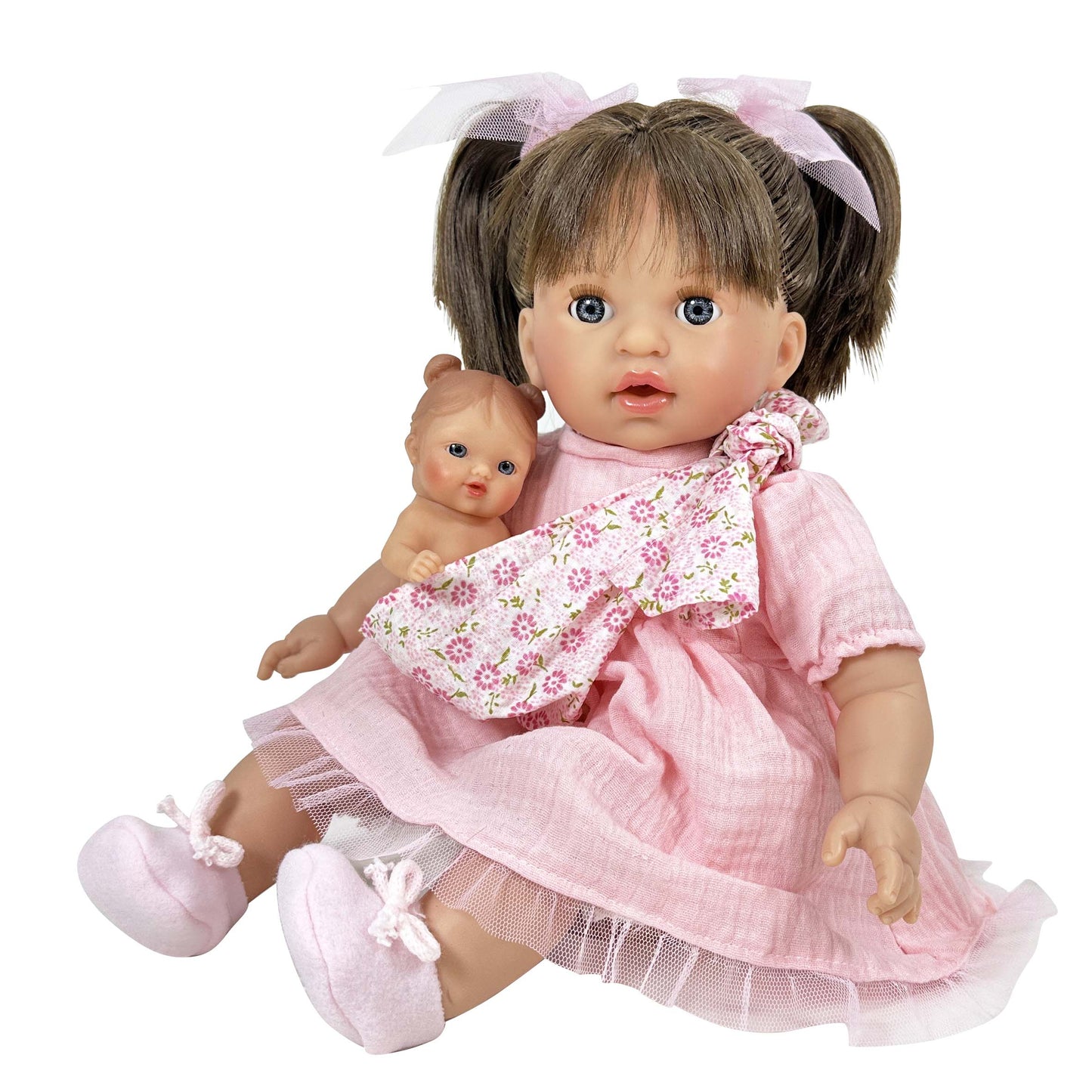 Doll in a pink dress holding a smaller doll on a white background