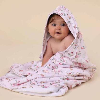 Baby wrapped in a floral-patterned blanket on a beige background