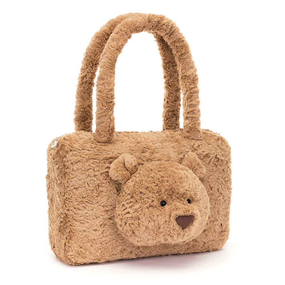 Teddy bear-shaped handbag with a face on a white background