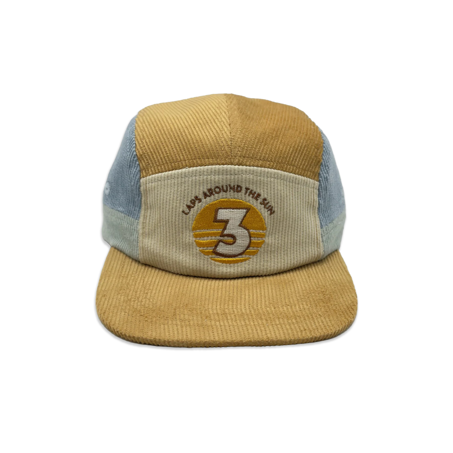 A 5-panel trucker cap made from mixed materials, featuring a mustard yellow corduroy front panel and brim, light blue mesh side panels, and a beige front patch with an embroidered circular logo.