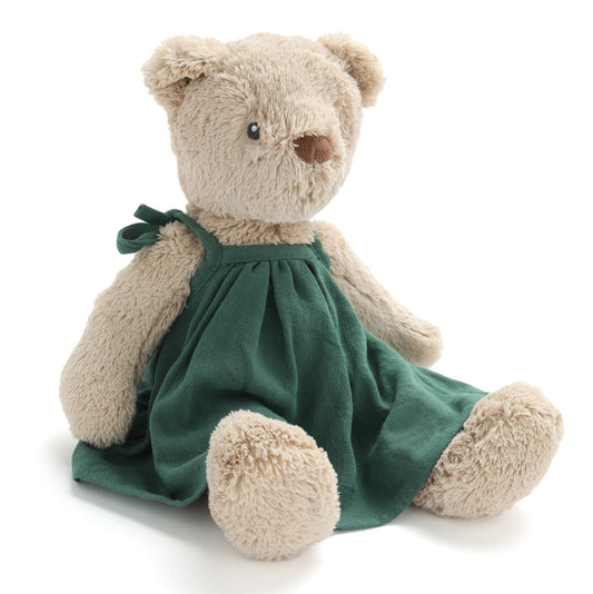 Stuffed teddy bear wearing a green dress on a white background