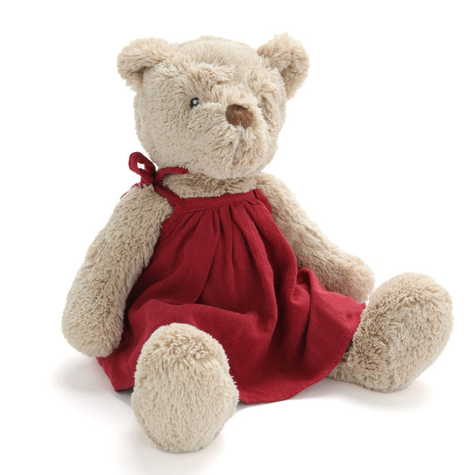 Stuffed teddy bear wearing a red dress on a white background