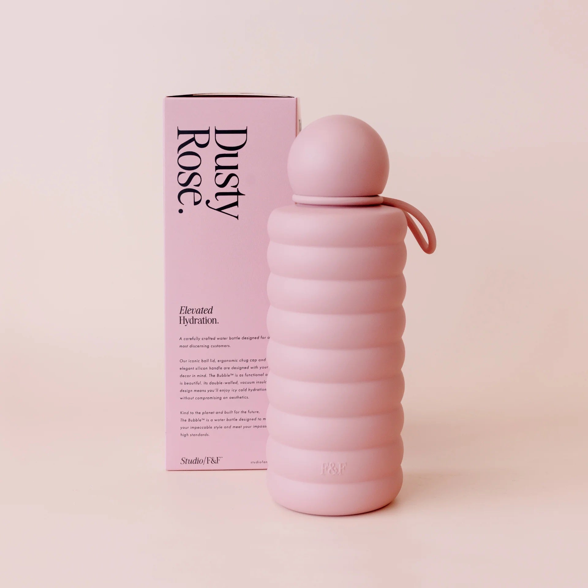 Pink water bottle with ribbed design and matching packaging on a light pink background