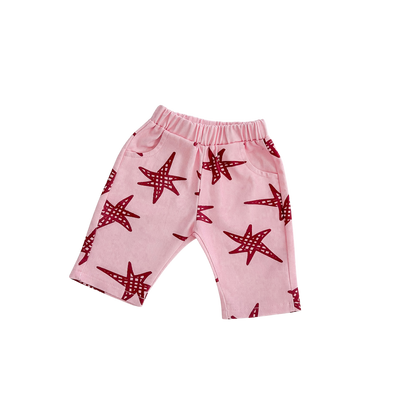 Pink pants with red starfish pattern on a white background