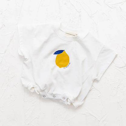 White baby onesie with a lemon design on a white textured background
