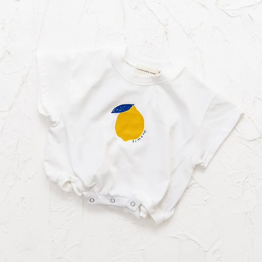 White baby onesie with a lemon design on a white textured background