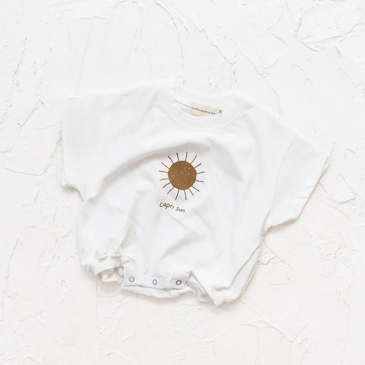 White baby onesie with a sun design on a white textured background