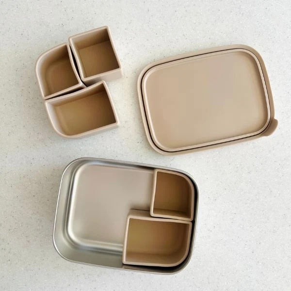Set of beige food containers with lids on a light background