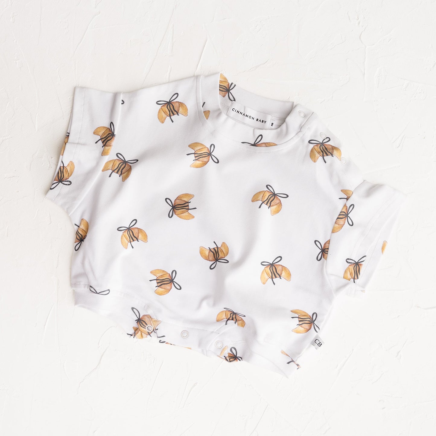 Baby romper with bee pattern on a white background
