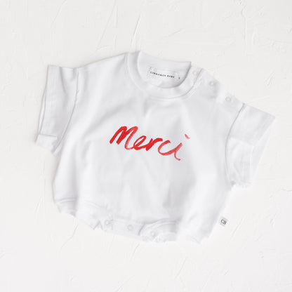 White t-shirt with red 'Merci' text on a white background