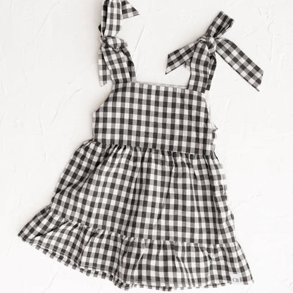 Black and white checkered dress with bow straps on a white background
