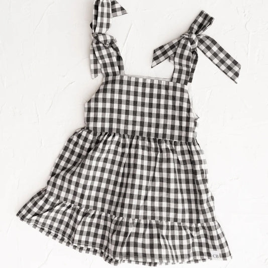 Black and white checkered dress with bow straps on a white background