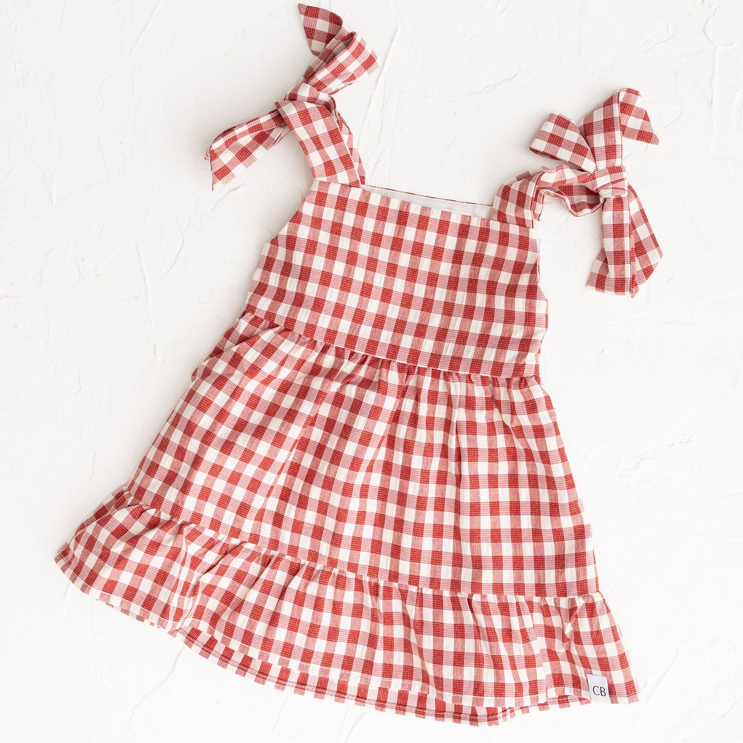 Red and white checkered dress with bow straps on a white background