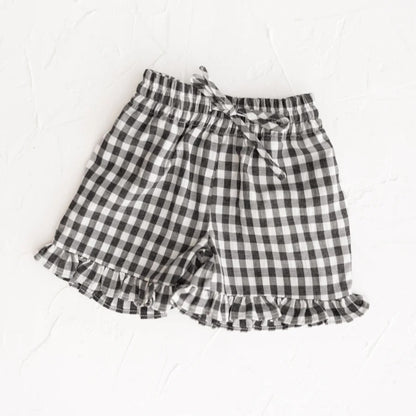 Black and white checkered shorts with ruffled edges on a white background