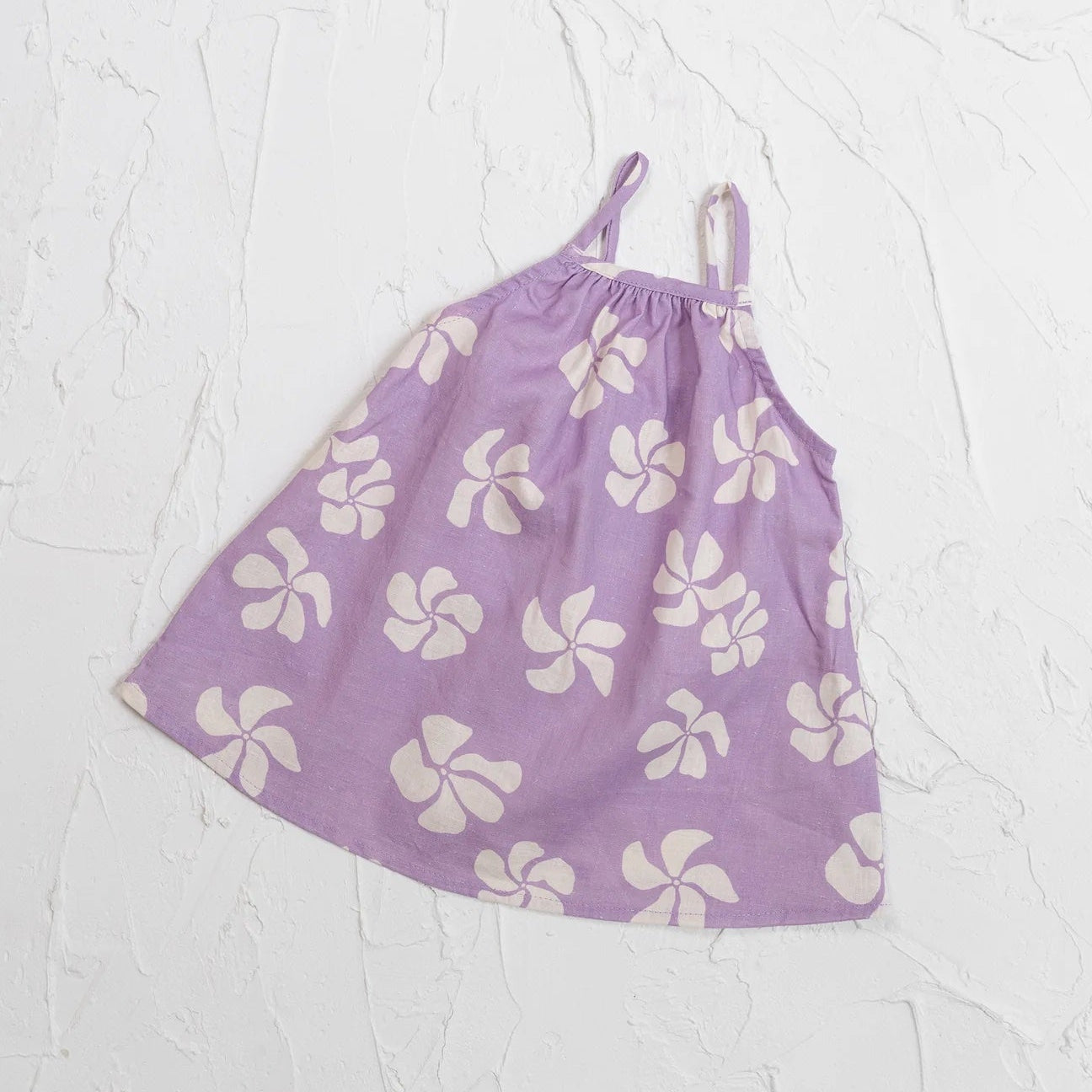 Purple dress with white floral pattern on a light gray background