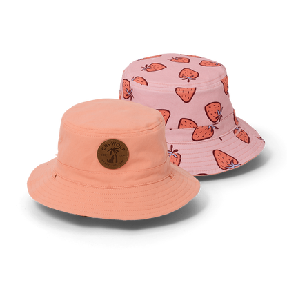 Two bucket hats, one peach and one pink with strawberry pattern, on a white background.