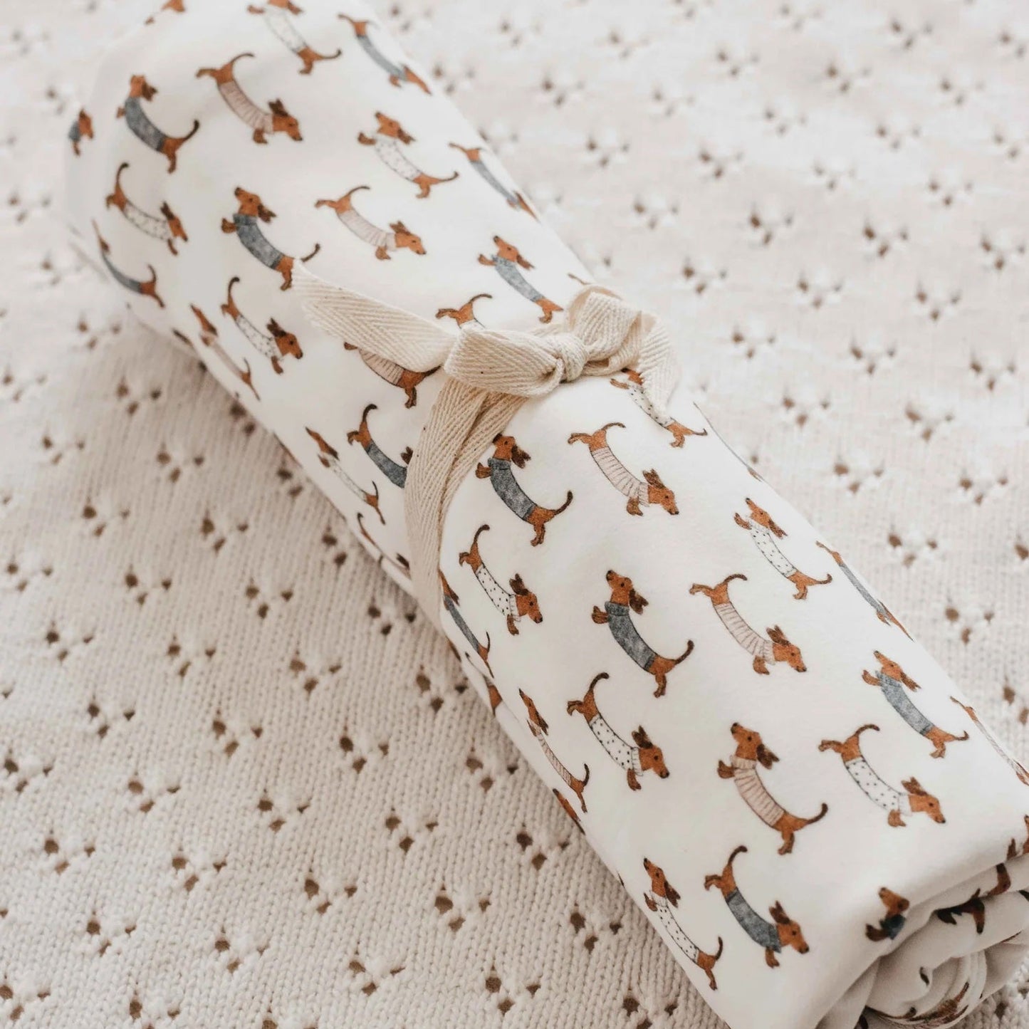 Rolled-up fabric with dog pattern on a textured surface