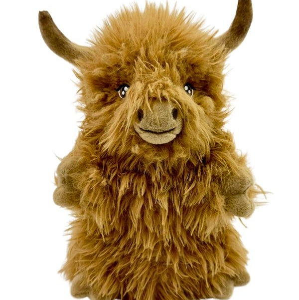 Plush toy of a fluffy brown highland cow on a white background