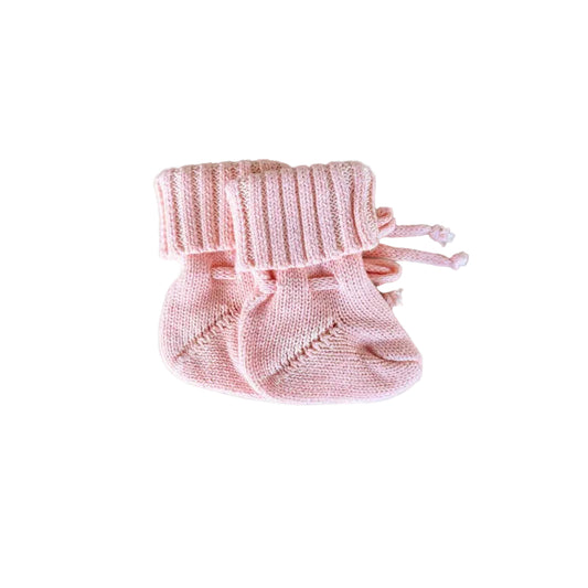 Pink baby booties on a light gray background