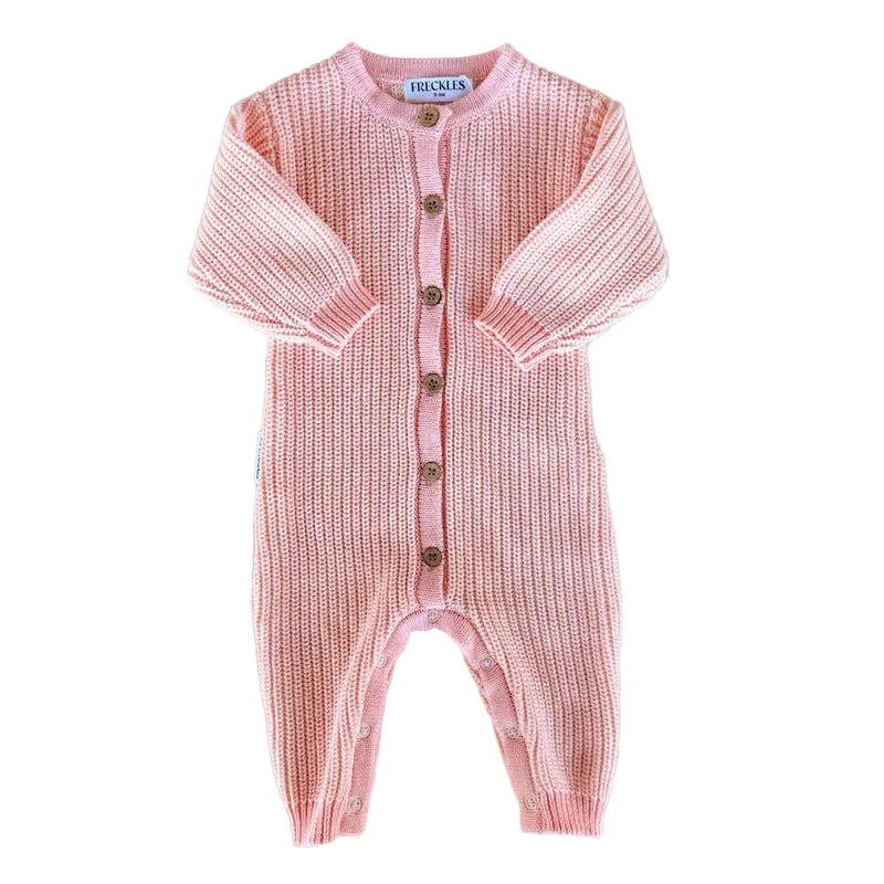 Pink knitted baby romper with button details on a light gray background
