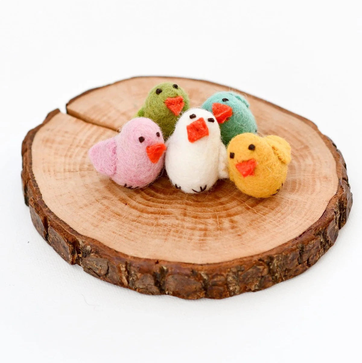 Five colorful bird-shaped toys on a wooden log