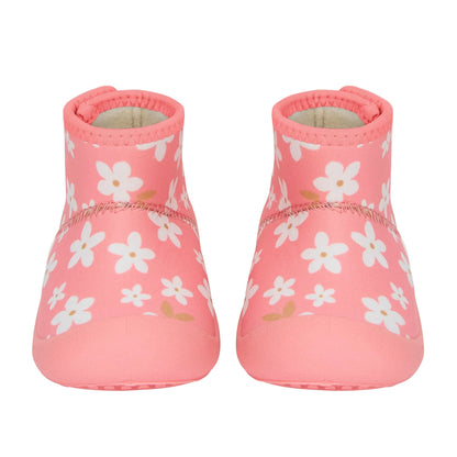 Pair of pink baby shoes with white floral pattern on a light gray background