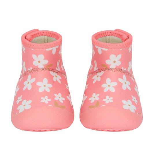 Pair of pink baby shoes with white floral pattern on a light gray background