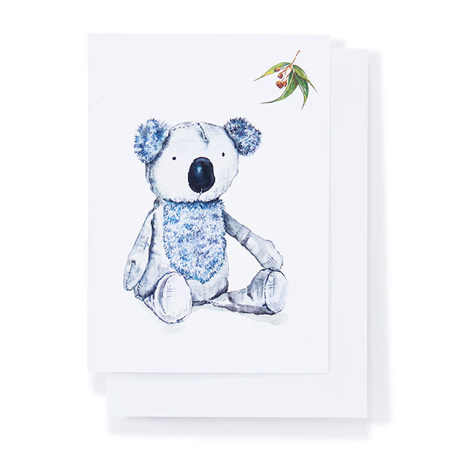 Stuffed koala toy with floral details on a white background