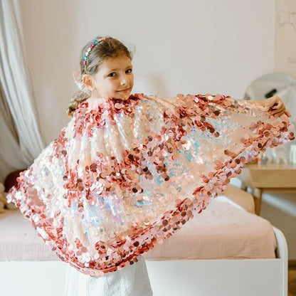 Young girl holding a floral shawl in a bedroom setting