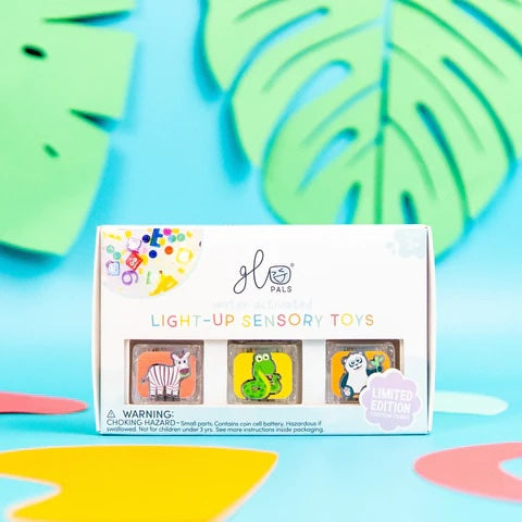 Box of Glo Pals light-up sensory toys on a colorful background with leaf designs