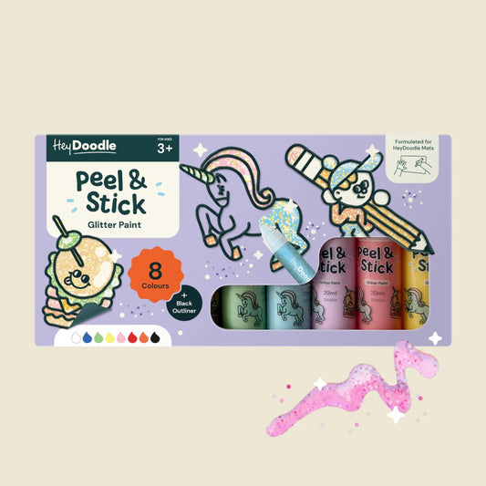 Packaging of Hey Doodle peel & stick glitter paint with cartoon characters on a beige background
