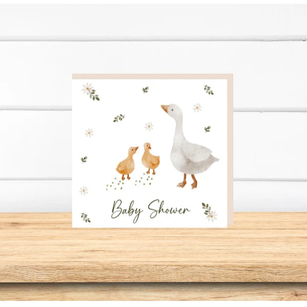 Framed baby shower card with a goose and two ducklings on a white background