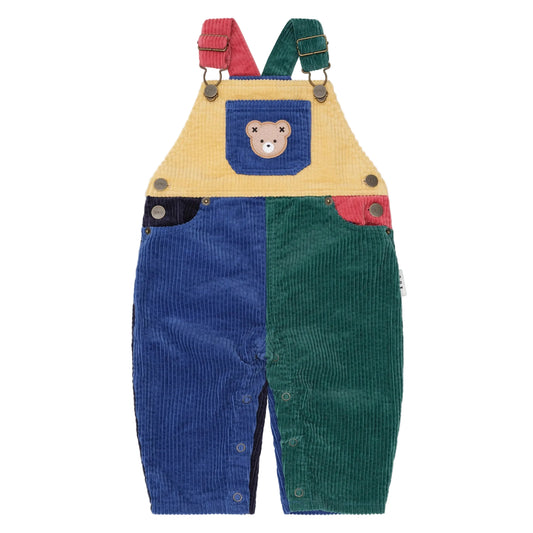 Children's colorful corduroy overalls with a bear patch on a beige background