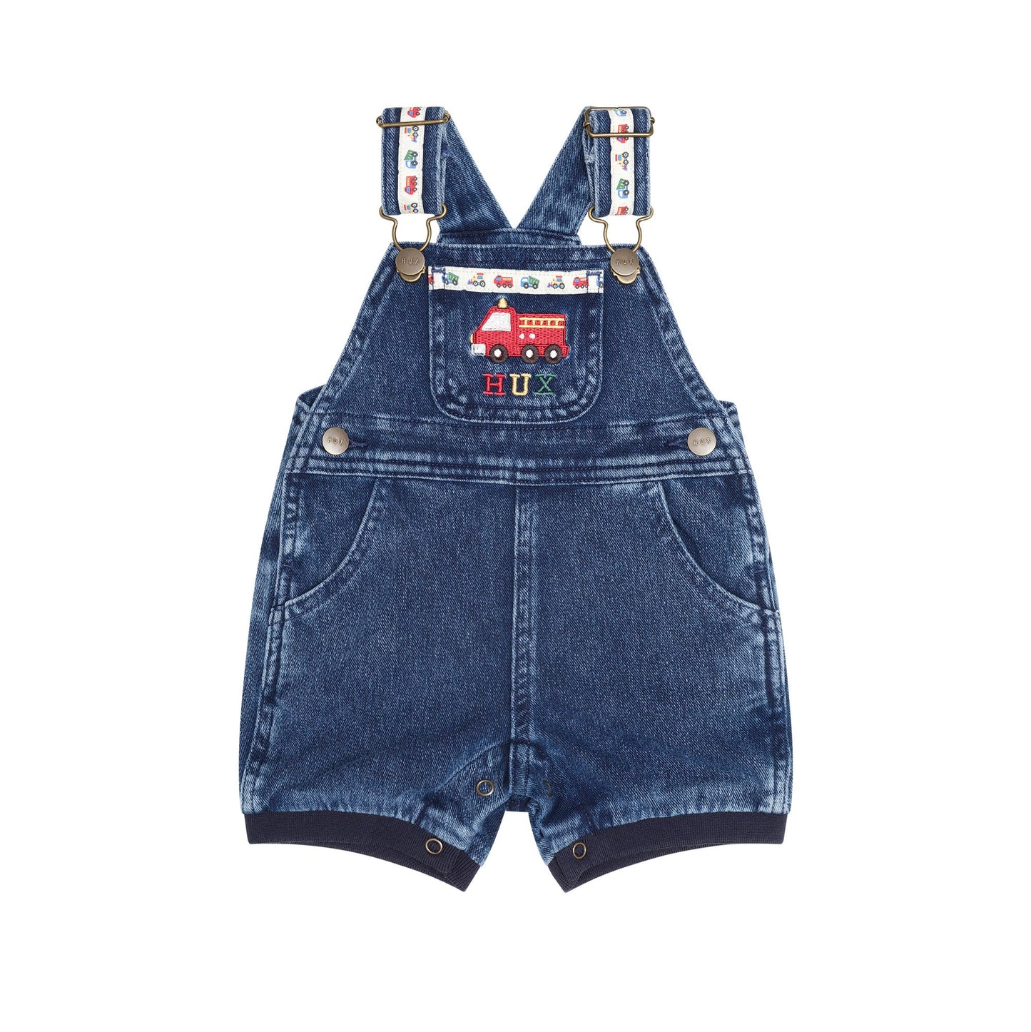 A pair of baby denim overall shorts with adjustable suspenders, featuring a red fire truck patch on the chest pocket and a colorful patterned strap detail, shown against a plain white background.