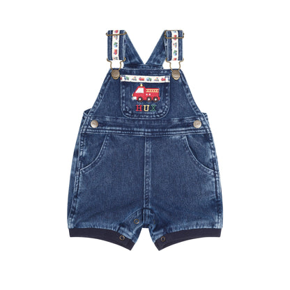 A pair of baby denim overall shorts with adjustable suspenders, featuring a red fire truck patch on the chest pocket and a colorful patterned strap detail, shown against a plain white background.