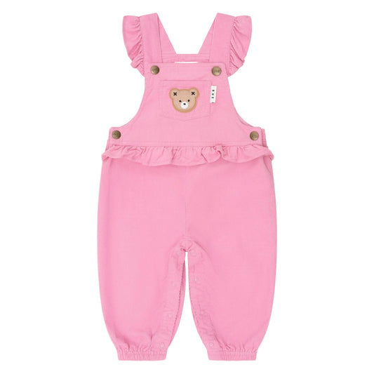 Pink baby romper with ruffled straps and teddy bear design on a light pink background